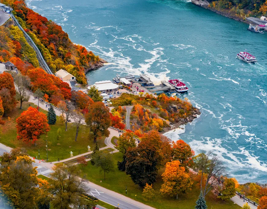 Niagara City Cruises boat approaching the base of Horseshoe Falls in autumn