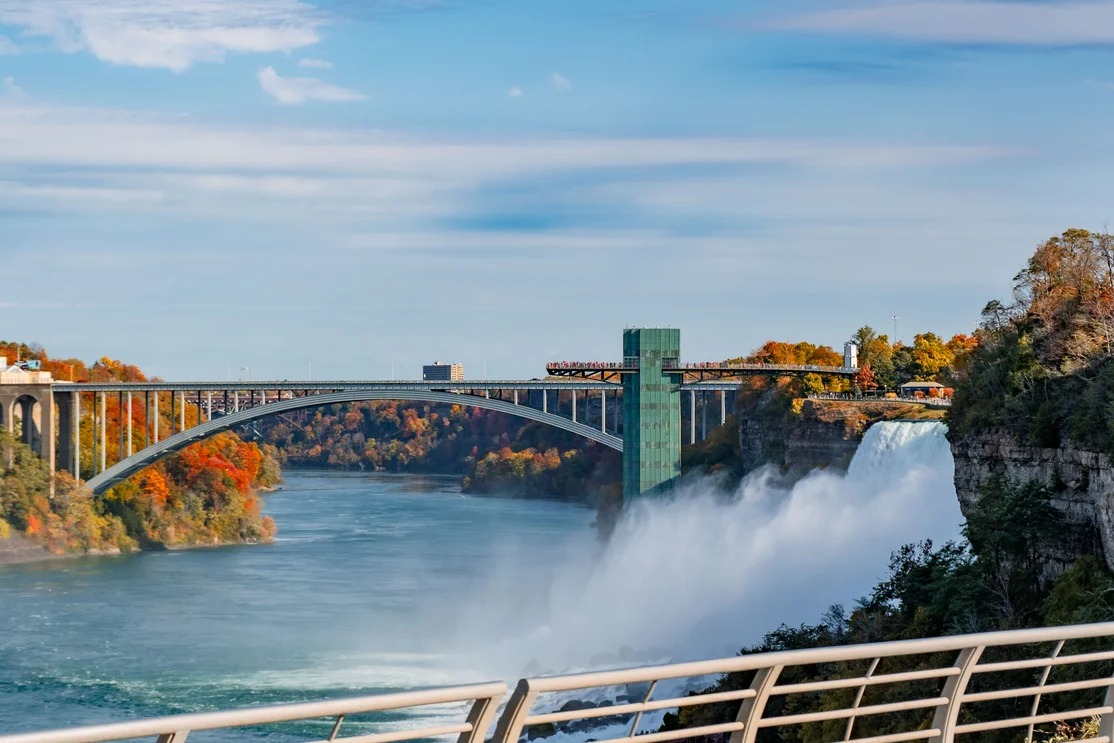 Rainbow Bridge connecting USA and Canada with autumn foliage at Niagara Falls