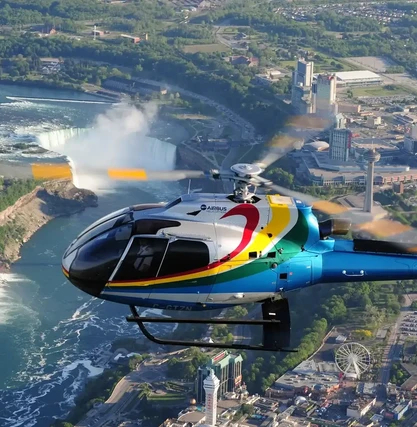 Colorful helicopter tour flying over Niagara Falls, offering a breathtaking aerial perspective of the falls and cityscape