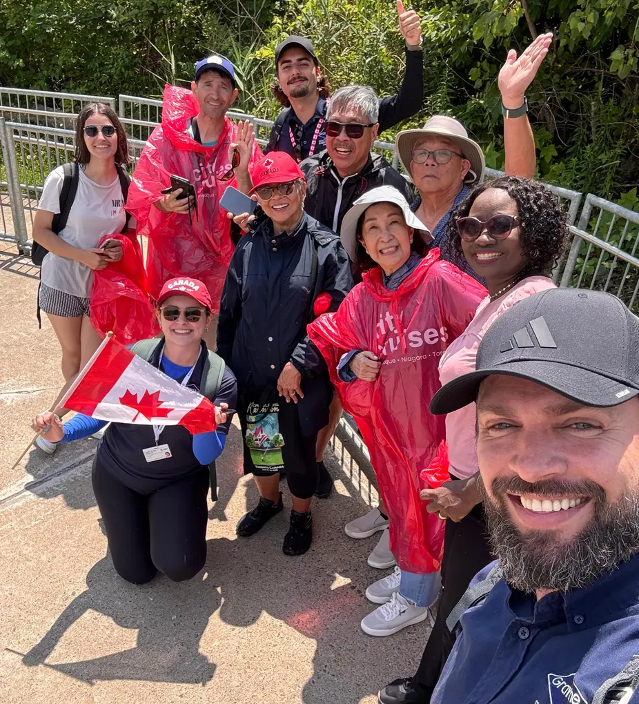 Happy Gray Line tour group with guide taking selfie after enjoying Niagara City boat cruise experience