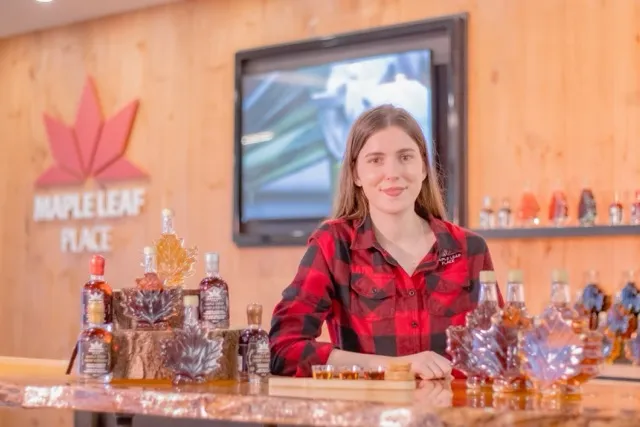 Guide presenting maple syrup tasting at Maple Leaf Place