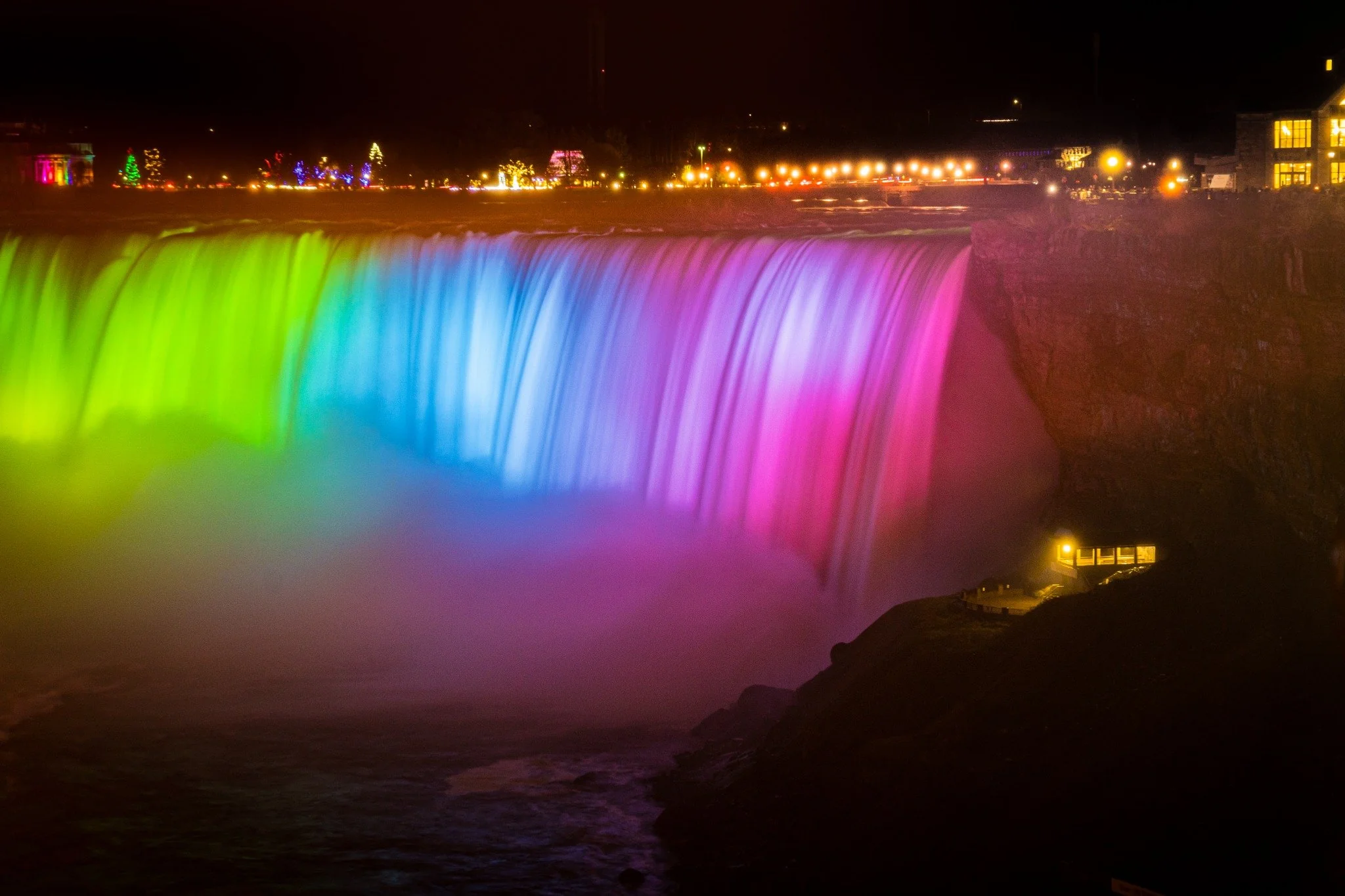 Closeup of colorful lights illuminating Niagara Falls at night during Winter Festival