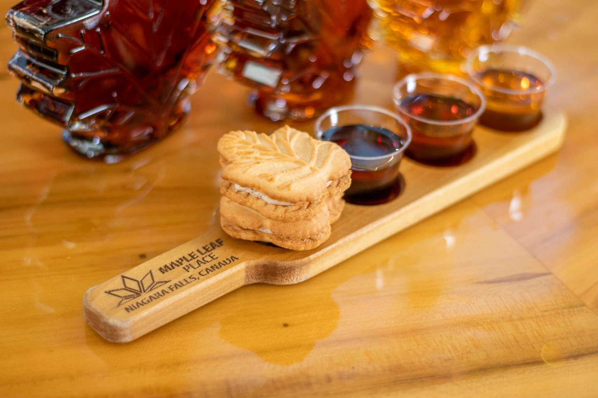 Maple syrup tasting display with Canadian treats at Maple Leaf Place